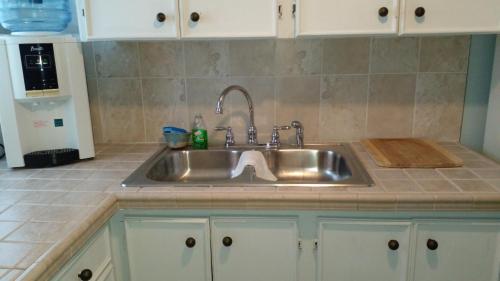 a kitchen counter with a stainless steel sink at Lynn's Cozy Cottage in Nassau