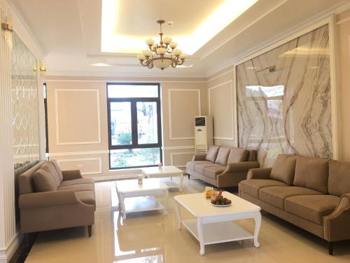 a living room with two couches and a table at TRA LINH HOTEL & RESTAURANTs in Hữu Lũng