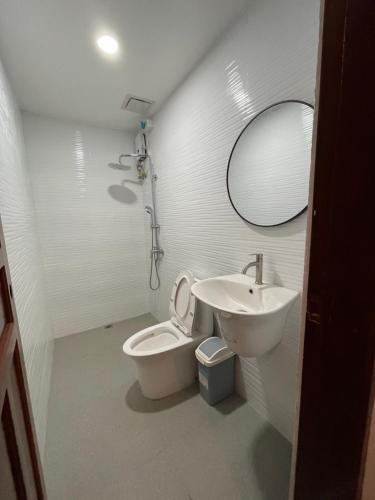 uma casa de banho com um lavatório, um WC e um espelho. em The Nook by Garolu em Castillejos