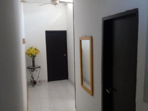 un pasillo con una puerta negra y un espejo en Room in House - Taminaka Hostel en Santa Marta - Shared room 3, en Santa Marta