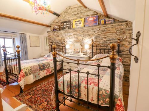 a bedroom with two beds and a stone wall at Ty Mawr in Blaenau-Ffestiniog