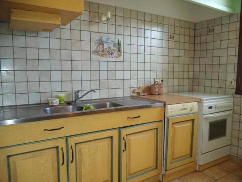 une petite cuisine avec un évier et une cuisinière dans l'établissement Appartement T3 avec véranda à 100m de la plage, 2 chambres, parking - Narbonne Plage - FR-1-229B-473, à Narbonne