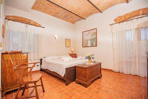 a bedroom with a bed and a table and chairs at Affitti Brevi Toscana - A due passi dal Mare in Magliano in Toscana