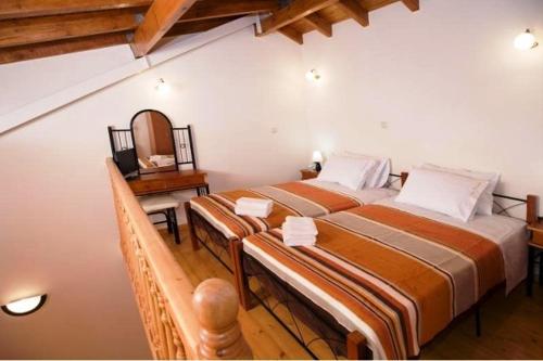 a bedroom with two beds and a table with a mirror at Irene Maisonettes in Chania