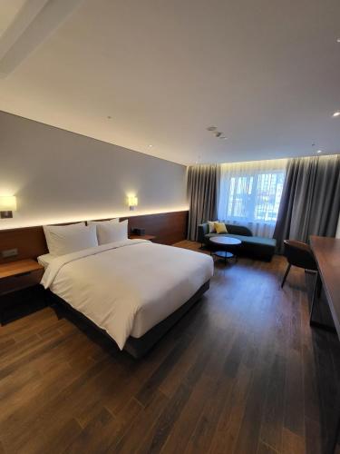 a bedroom with a large bed and a living room at The Marevo in Suwon