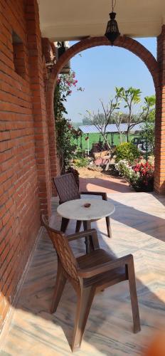 a table and a chair sitting on a patio at lalita homestay countryside in Khajurāho