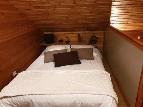 um quarto com uma cama num chalé de madeira em Chalet Bois Cosy em Ferdrupt
