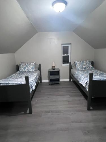 Cette chambre comprend 2 lits et une table. dans l'établissement LOVELY/ COZY HOUSE MIDDLETOWN, OH, à Middletown