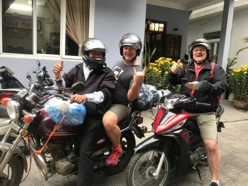 a group of three people sitting on motorcycles at Maily Hostel in Hue