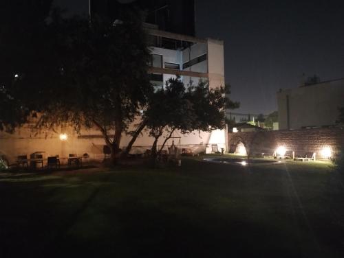 un edificio con un árbol delante de él por la noche en Departamento privado en Casa Barranca Yaco en Córdoba