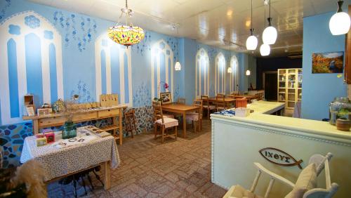 restauracja z niebieskimi ścianami, stołami i krzesłami w obiekcie Fish Hostel w mieście Yingge