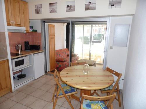 une cuisine et une salle à manger avec une table et des chaises dans l'établissement Appartement cosy 2 pièces cabine, 2 terrasses, parking, à 140m de la plage ! - FR-1-326-538, à Marseillan