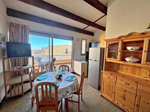 d'une salle à manger avec une table et d'une cuisine avec un balcon. dans l'établissement Appartement 4 pers avec vue mer proche plage, animaux et parking inclus - FR-1-387-85, à Marseillan