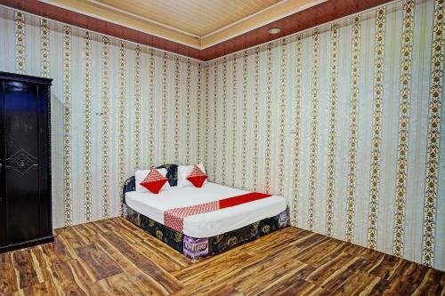 1 dormitorio con 1 cama en una habitación con papel pintado en OYO 92240 Taman Wisata Iman Ii, en Hutamanik