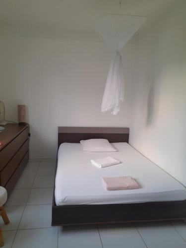 a bedroom with a bed with white sheets and pink towels at BaySide in Fort-de-France