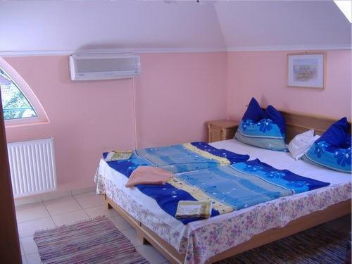 - une chambre dotée d'un grand lit avec des draps bleus dans l'établissement Judit haus, à Balatonfüred
