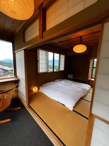 a large bed in a room with windows at NIKONOS III in Nozawa Onsen