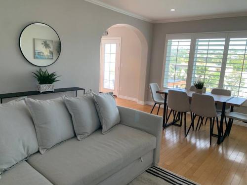 a living room with a white couch and a table at Steps To The BEST Beach . Surf . Spa . Main Street in Encinitas