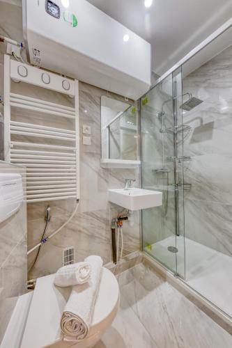 une salle de bain avec une douche, des toilettes et un lavabo dans l'établissement Les Bleus de Paris studio flat, à Gentilly