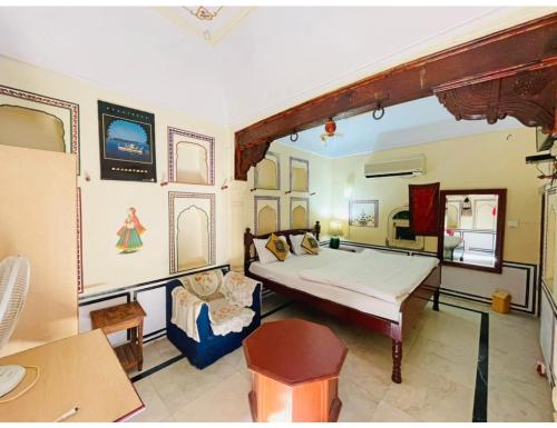 a bedroom with a bed and a chair in a room at Singhasan Haveli, Mandawa in Mandāwa