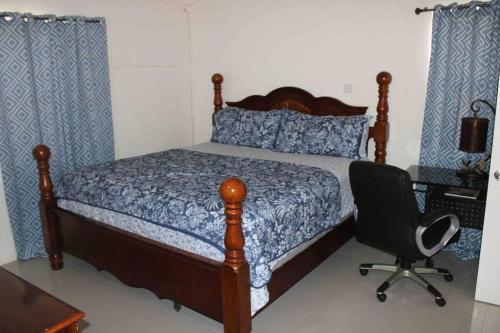 a bedroom with a bed and a desk and a chair at Hidden Escape,pool,gated,gym,air-conditioned, in Mammee Bay