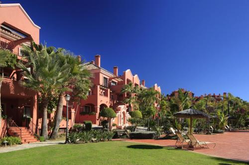 a large building with a large lawn and trees at Vasari Resort in Marbella