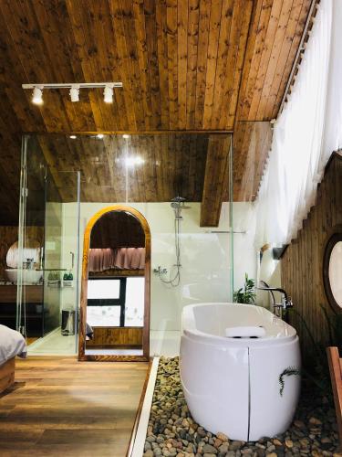 a bathroom with a large tub and a shower at Nhà Sói Homestay Da Lat in Da Lat
