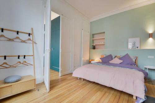 a bedroom with a bed with purple pillows at - Le Manon !Gare - topappartnancy in Nancy