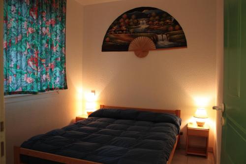Un dormitorio con una cama con dos lámparas y un cuadro. en Moliets plage, Résidence OPEN SUD, en Moliets-et-Maa