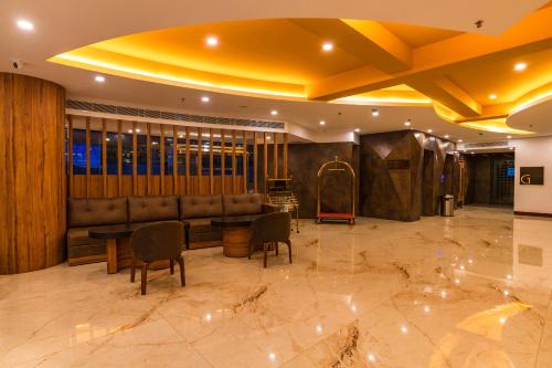 a lobby with a couch and a table and chairs at Classic Regency in Alleppey
