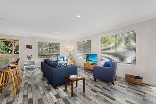 a living room with two couches and a television at Marine Villa in Smiths Lake