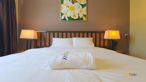 a bed with a towel on it with two lamps at Gold Coast Morib Studio l Apartment I Penthouse in Banting