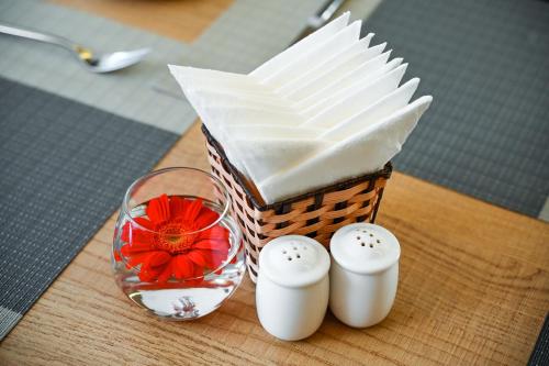 a wicker basket with a red flower next to a glass at Muong Thanh Grand Saigon Centre Hotel in Ho Chi Minh City