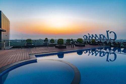 a swimming pool on top of a building with the sunset at Classic Regency in Alleppey