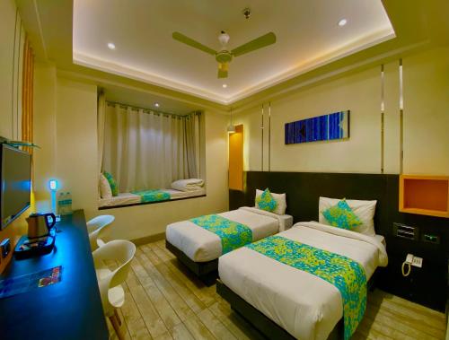 a hotel room with two beds and a desk at Ace Iconic in Greater Noida