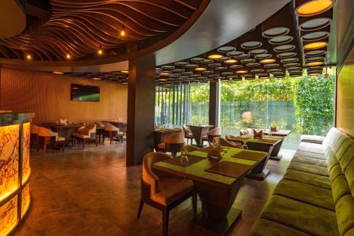 a restaurant with tables and chairs and a large window at Classic Regency in Alleppey