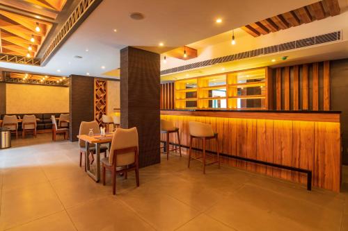 a restaurant with tables and chairs and a bar at Classic Regency in Alleppey