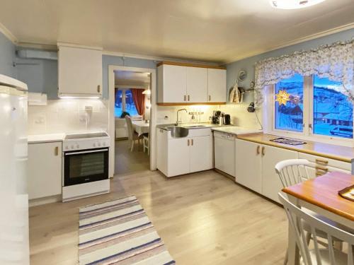une cuisine avec des appareils électroménagers blancs et une salle à manger dans l'établissement Holiday home STONGLANDSEIDET II, à Stonglandseidet