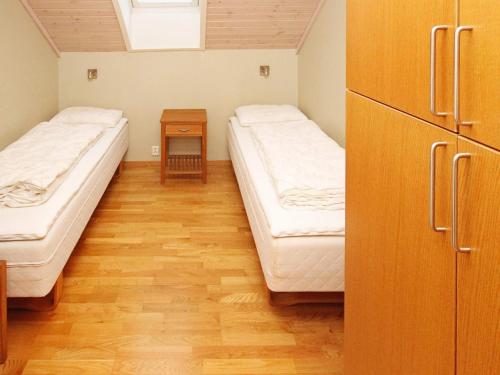 a room with two beds and a wooden floor at Holiday Home Foreneset in Jelsa