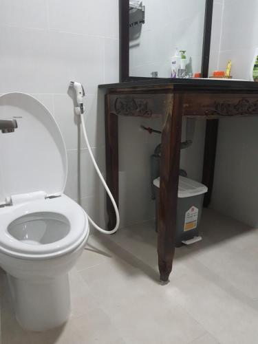 a bathroom with a toilet and a table with a mirror at Hoa Anh Đào Garden Hotel in Thuan An