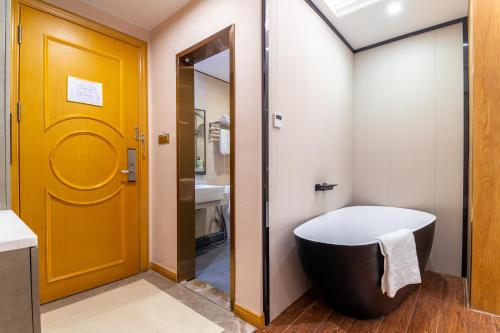 a bathroom with a toilet and a yellow door at Puzzle Hotel - Zhongshan 8th Road Chenjiaci Subway Station Branch in Guangzhou