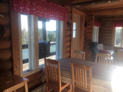 Tuliranta في Suonenjoki: غرفة مع طاولة وكراسي في كابينة خشب