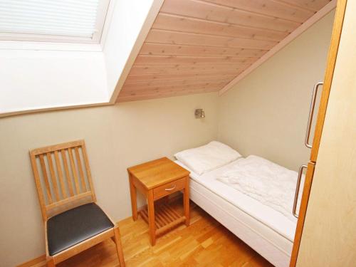 een kleine slaapkamer met een bed en een stoel bij Five-Bedroom Holiday home in Jelsa 1 in Jelsa