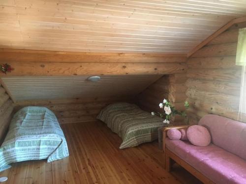 een kamer met 2 bedden in een blokhut bij Tuliranta in Suonenjoki