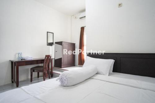 - une chambre avec un lit, un bureau et une chaise dans l'établissement Katup Guest House Syariah Mitra RedDoorz, à Yogyakarta