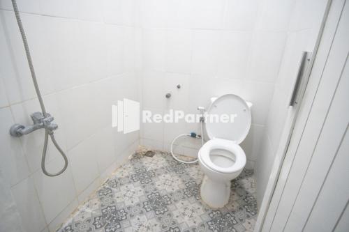 - une salle de bains avec des toilettes blanches dans une cabine dans l'établissement Katup Guest House Syariah Mitra RedDoorz, à Yogyakarta