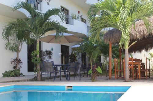 a resort with a pool and chairs and palm trees at hotel stella maris tulum in Tulum