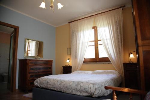 a bedroom with a bed and a window and a dresser at Su Livariu in Siamaggiore