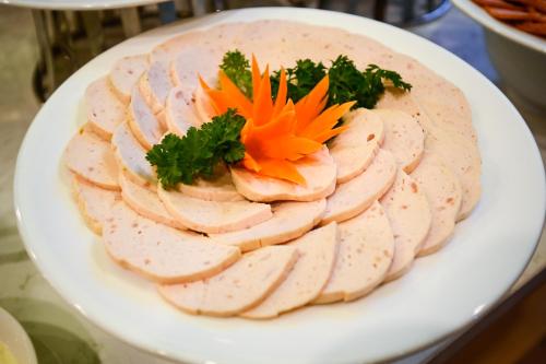 a plate of chicken with a orange flower on it at Muong Thanh Grand Saigon Centre Hotel in Ho Chi Minh City