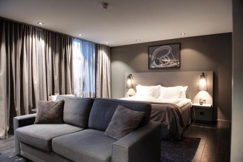 a hotel room with a bed and a couch at The Lamp Hotel & Spa in Norrköping